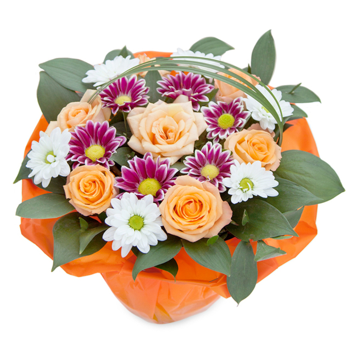 This exquisite bouquet, viewed from a softly elevated angle, radiates both freshness and thoughtful design-every element in perfect harmony. The arrangement, created by seasoned New Cross florists, is anchored by full-bodied roses whose petals shift from light peach to a radiant orange, their blooms opening in soft layers much like the early sunrise over New Cross's vibrant urban skyline. White daisy-like chrysanthemums peek from among the roses, their delicate petals forming airy halos around cool green centers reminiscent of peaceful grassy corners beside New Cross's historic streets. Interspersed throughout the bouquet, deep magenta and purple chrysanthemums shimmer, their densely furled petals bursting with color around bright lime-green hearts. Mingling with the flowers, an abundance of glossy, dark green ruscus leaves creates a layered, textured foundation that enhances the arrangement's depth. A slender sweep of bear grass arches lightly overhead, suggesting movement and adding a contemporary flair. The entire bouquet is cradled at its base in lively, crinkled orange wrapping, echoing the community's dynamic flair while tying together the bouquet's warm and vivid palette. This floral creation embodies the spirit of celebration and heartfelt connection-whether destined for a birthday breakfast, a cheerful thank you, or as a radiant welcome home in the heart of New Cross. Each gathered bloom and verdant leaf tells a story of local pride and expert floristry.